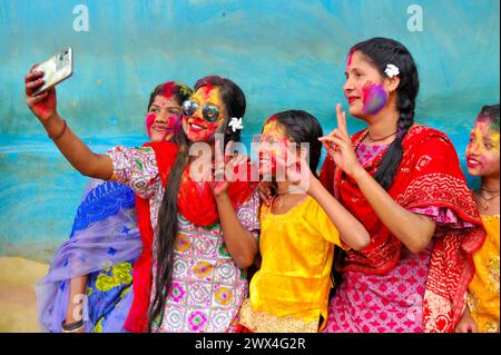 Sylhet, Bangladesh. 27 marzo 2024. 27 marzo 2024, Sylhet, Bangladesh: Le donne del Bangladesh si selfie dopo aver dipinto i loro volti con colori come Rainbows come parte della celebrazione dell'annuale festival indù dei colori, noto come Holi festival che segna l'inizio della primavera. Il 27 marzo 2024 a Sylhet, Bangladesh. (Foto di MD Rafayat Haque Khan/ Eyepix Group/Sipa USA) credito: SIPA USA/Alamy Live News Foto Stock