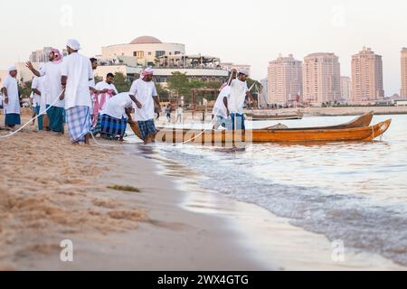 I pescatori arabi su un'antica barca di legno vanno a pescare al tramonto. Conservazione delle tradizioni nazionali, dell'artigianato antico, dello stile di vita storico Foto Stock