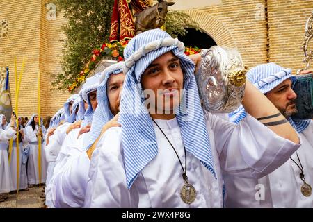 Almuneca, Spagna. La settimana di Pasqua ad Almuneca, Spagna, inizia con il primo grande evento è la domenica delle Palme (Domingo de Ramos), la festa che si tiene esattamente una settimana prima della domenica di Pasqua, per commemorare il famoso ingresso di Gesù a Gerusalemme su un asino. Le confraternite organizzano ogni giorno le processioni che sfilano per le strade e le piazze portando bellissimi "pasos" e "tronos" adornati di fiori e immagini religiose che vengono portate sulle spalle dei partecipanti. Qui escono dalla Chiesa del Encarnación a Almuñécar all'inizio della sfilata. 24 marzo 2024 David Smith/Alamy Foto Stock