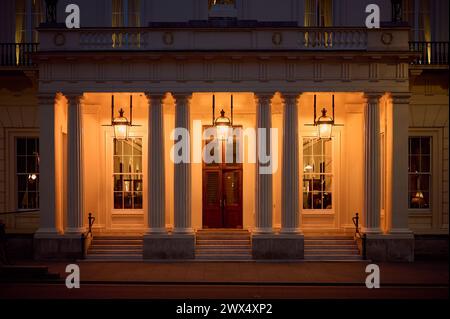 19 marzo 2024 - Londonuk: Vista notturna dell'ingresso all'edificio londinese in stile georgiano illuminato all'Athenaeum Club Foto Stock