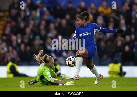 Catarina Macario (a destra) del Chelsea tenta un tiro in porta salvato dalla portiere dell'Ajax Regina Van Eijk durante la partita di andata dei quarti di finale di UEFA Champions League allo Stamford Bridge di Londra. Data foto: Mercoledì 27 marzo 2024. Foto Stock