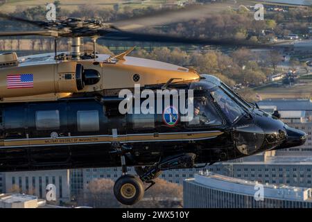 Il capitano dell'esercito americano Chris Bissett, un pilota assegnato alla compagnia Alpha, 12th Aviation Battalion, la Army Aviation Brigade, ondata come Warrant Officer Eric Mendoza, pilota UH-60M, vola un VH-60M Black Hawk sopra Downtown Washington, D.C., 25 marzo 2024. Il 12th Aviation Battalion utilizza i Black Hawk VH-60M "Gold top" per condurre il trasporto aereo prioritario a sostegno della leadership senior del Dipartimento dell'Esercito e di altri alti funzionari del Dipartimento della difesa. (Foto U.S. Air Force di Nicholas A. Priest) Foto Stock