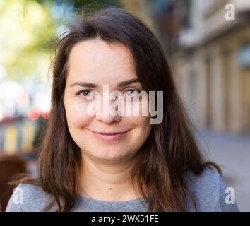 Ritratto ravvicinato di una pensiva bruna che cammina lungo la strada della città Foto Stock