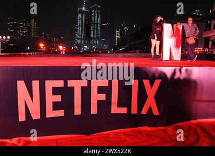 Mumbai, India. 27 marzo 2024. Le persone posano per una foto vicino al logo di Netflix in un evento promozionale per una serie televisiva Netflix in arrivo "Heeramandi : The Diamond Bazaar" a Mumbai. Credito: SOPA Images Limited/Alamy Live News Foto Stock