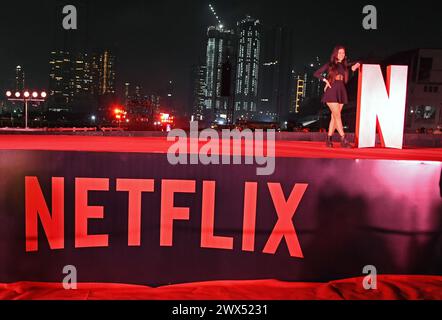 Mumbai, India. 27 marzo 2024. Una donna posa per una foto vicino al logo di Netflix in un evento promozionale per una serie televisiva Netflix in arrivo "Heeramandi : The Diamond Bazaar" a Mumbai. Credito: SOPA Images Limited/Alamy Live News Foto Stock