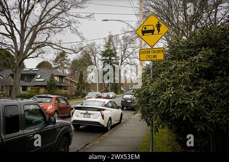 Foto di un cartello di avvertimento giallo sui bambini in bicicletta nel quartiere di Oak Bay, nella capitale della provincia. Foto Stock