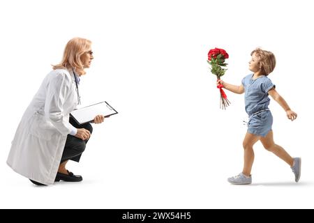 Bambina con un mucchio di fiori che corre verso una dottoressa isolata su sfondo bianco Foto Stock