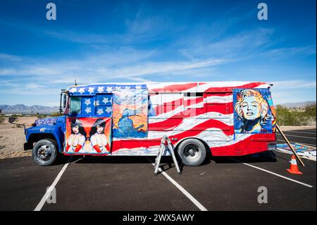 Un artista appende i dipinti su un autobus personalizzato con bandiera americana. Lake Havasu, Arizona, Stati Uniti. Foto Stock