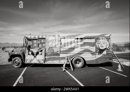 Un artista appende i dipinti su un autobus personalizzato con bandiera americana. Lake Havasu, Arizona, Stati Uniti. Foto Stock
