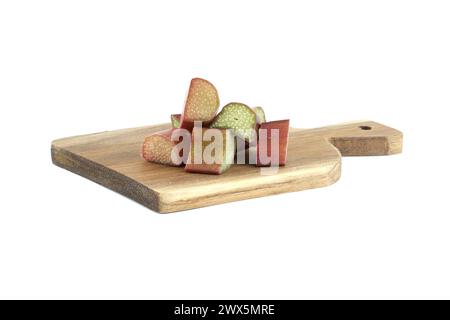 Varietà di gambi di rabarbaro di vari colori, dal verde pallido al rosso intenso su tagliere di legno isolato su sfondo bianco Foto Stock