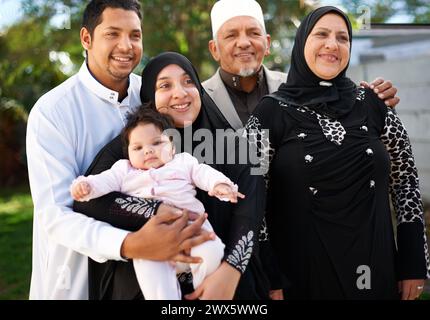 Famiglia, sorridi e insieme per eid, islam e ramadan per festività religiose e felici. Persone anziane, mamma e papà con il bambino in giardino o in giardino per Foto Stock