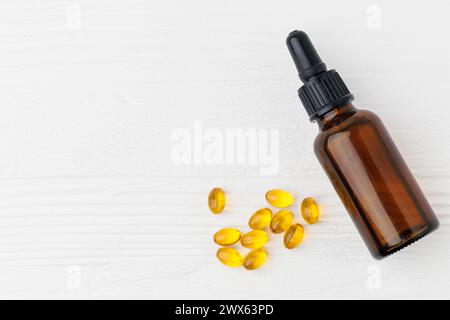 D3 vitamina in flacone e capsule di gel morbido olio su un tavolo di legno bianco, vista dall'alto Foto Stock