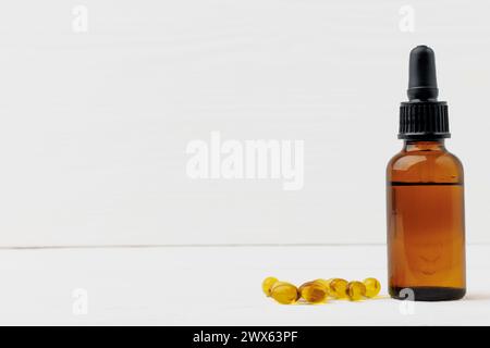D3 vitamina in bottiglia e capsule di gel morbido olio su un tavolo di legno bianco Foto Stock