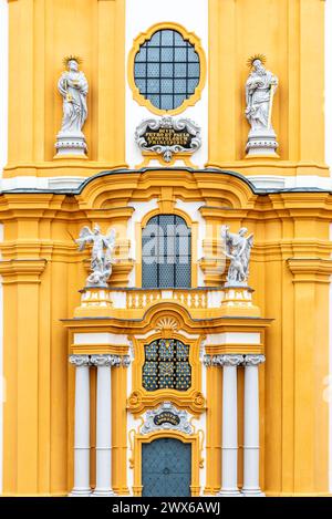 L'ornata facciata barocca gialla e bianca dell'Abbazia di Melk, adornata da sculture e finestre decorative, riflette la grandezza dello storico monastero. Austria Foto Stock