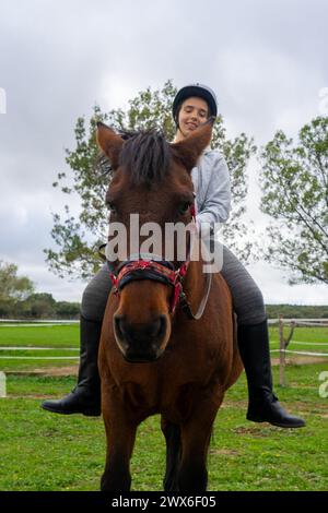 Giovane donna che tiene una lezione di equitazione Foto Stock