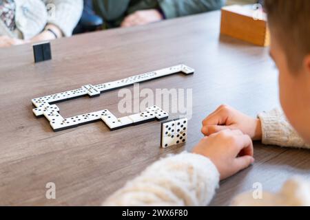 Ragazzo che gioca a domino con la sua bisnonna in una casa di cura Foto Stock