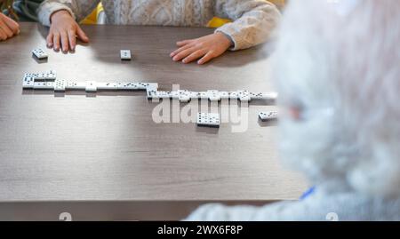 Ragazzo che gioca a domino con la sua bisnonna Foto Stock