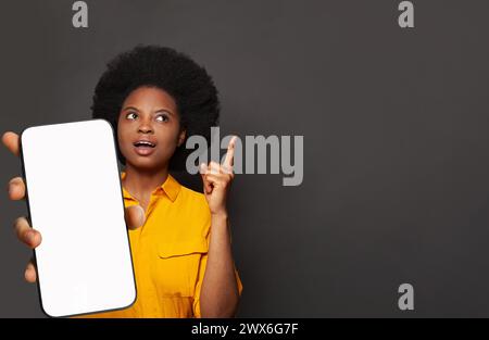 La donna di puntamento contiene un telefono con display vuoto. Donna con smartphone Foto Stock