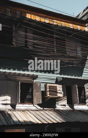 Una struttura in legno vintage con luce solare che scorre attraverso finestre e persiane aperte. Foto Stock