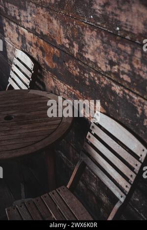 Le due sedie e un tavolo di legno con due sedie vuote disposte in fila. Foto Stock