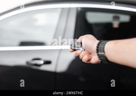 La mano dell'uomo tiene le chiavi della macchina. Noleggia un'auto. Prova su strada. Acquisto del trasporto Foto Stock