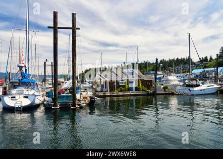 Una casa galleggiante al porticciolo di Cowichan Bay tra le barche da diporto ormeggiate al molo in una luminosa giornata estiva. Foto Stock