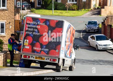 Un furgone Tesco consegna a domicilio consegna un ordine a una casa a Queensbury, West Yorkshire, Regno Unito. Nel giugno 2007, Tesco.com è diventata la prima società di consegna a domicilio nel Regno Unito a fornire ai clienti la possibilità di consegnare gli acquisti in scatole verdi senza borse, nel tentativo di ridurre la quantità di borse utilizzate come parte dell'impegno ecologico di Tesco. In cambio, i clienti che usufruiscono della borsa gratuita riceveranno punti green clubcard. Dopo aver provato un servizio di consegna completamente senza sacco, Tesco ha smesso di utilizzare sacchetti di plastica e carta per tutti gli ordini online consegnati a partire dal 19 agosto 2019. Foto Stock