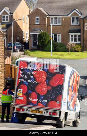 Un furgone Tesco consegna a domicilio consegna un ordine a una casa a Queensbury, West Yorkshire, Regno Unito. Nel giugno 2007, Tesco.com è diventata la prima società di consegna a domicilio nel Regno Unito a fornire ai clienti la possibilità di consegnare gli acquisti in scatole verdi senza borse, nel tentativo di ridurre la quantità di borse utilizzate come parte dell'impegno ecologico di Tesco. In cambio, i clienti che usufruiscono della borsa gratuita riceveranno punti green clubcard. Dopo aver provato un servizio di consegna completamente senza sacco, Tesco ha smesso di utilizzare sacchetti di plastica e carta per tutti gli ordini online consegnati a partire dal 19 agosto 2019. Foto Stock