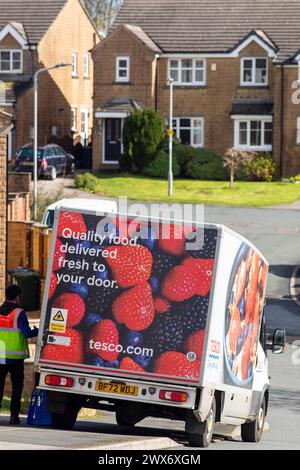 Un furgone Tesco consegna a domicilio consegna un ordine a una casa a Queensbury, West Yorkshire, Regno Unito. Nel giugno 2007, Tesco.com è diventata la prima società di consegna a domicilio nel Regno Unito a fornire ai clienti la possibilità di consegnare gli acquisti in scatole verdi senza borse, nel tentativo di ridurre la quantità di borse utilizzate come parte dell'impegno ecologico di Tesco. In cambio, i clienti che usufruiscono della borsa gratuita riceveranno punti green clubcard. Dopo aver provato un servizio di consegna completamente senza sacco, Tesco ha smesso di utilizzare sacchetti di plastica e carta per tutti gli ordini online consegnati a partire dal 19 agosto 2019. Foto Stock