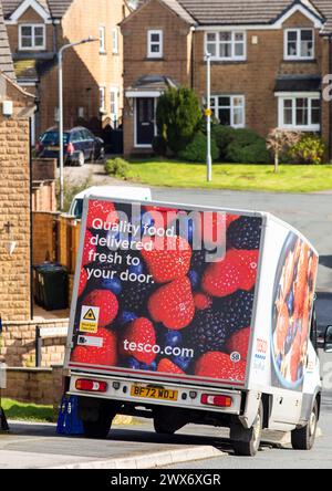 Un furgone Tesco consegna a domicilio consegna un ordine a una casa a Queensbury, West Yorkshire, Regno Unito. Nel giugno 2007, Tesco.com è diventata la prima società di consegna a domicilio nel Regno Unito a fornire ai clienti la possibilità di consegnare gli acquisti in scatole verdi senza borse, nel tentativo di ridurre la quantità di borse utilizzate come parte dell'impegno ecologico di Tesco. In cambio, i clienti che usufruiscono della borsa gratuita riceveranno punti green clubcard. Dopo aver provato un servizio di consegna completamente senza sacco, Tesco ha smesso di utilizzare sacchetti di plastica e carta per tutti gli ordini online consegnati a partire dal 19 agosto 2019. Foto Stock