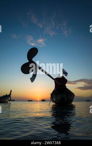 Splendido tramonto sull'isola tropicale di Koh Tao, Thailandia. Profilo dell'elica del motore dell'imbarcazione a coda lunga Foto Stock