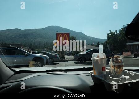 Una vista dal parabrezza dell'auto su un McDonalds Foto Stock