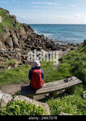Posto a sedere con vista su Porthgwarra Cove sul percorso costiero della Cornovaglia meridionale a marzo, Cornovaglia, Inghilterra, Regno Unito Foto Stock