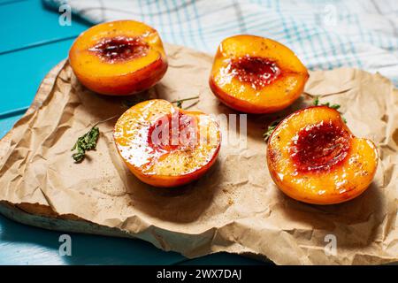 Pesche cotte al forno con miele e cannella su fondo di legno blu. dessert estivo Foto Stock