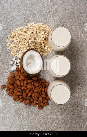 Tipi di latte vegetale in bicchieri. Latte di avena, cocco e mandorle. Foto Stock