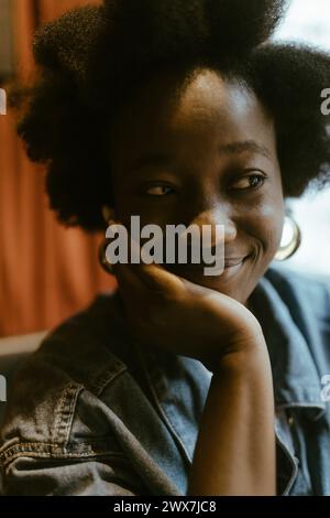 Giovane donna sorridente che si appoggia al gomito al ristorante Foto Stock
