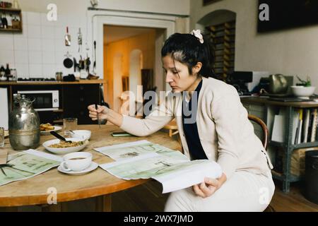 Architetto donna che esamina il progetto mentre lavora a casa Foto Stock