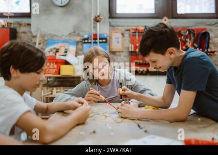 Studenti scolastici uomini e donne curiosi che lavorano su progetti di robotica in classe tecnologica a scuola Foto Stock