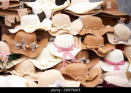 Sulla strada viene visualizzato un mucchio di cappelli di paglia Foto Stock