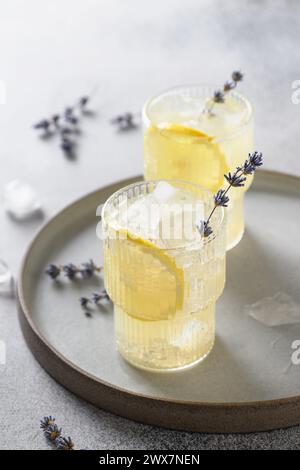 Limonata di lavanda frizzante in bicchieri su sfondo grigio. Formato verticale. Primo piano. Bevanda analcolica estiva con aroma fresco. Foto Stock