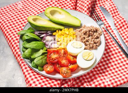 Sana ciotola per pranzo: Uova, tonno, avocado, pomodori ciliegini insalata di mais cipolla Foto Stock