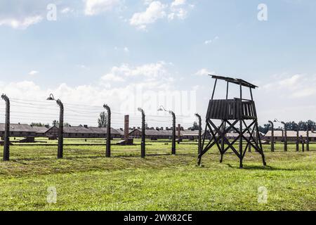 Recinzioni in filo metallico, torre di guardia e caserme dei prigionieri nel campo di concentramento nazista di Auschwitz-Birkenau, Polonia Foto Stock