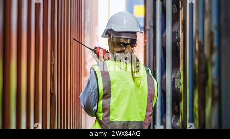 Una lavoratrice edile che utilizza un walkie-talkie in un cantiere Foto Stock