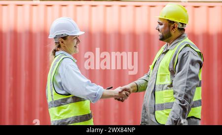 Una stretta di mano davanti a una struttura di container Foto Stock