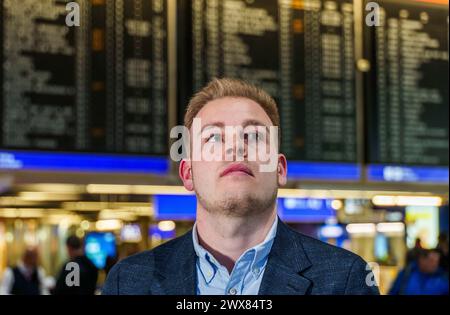 28 marzo 2024, Assia, Francoforte sul meno: Marvin Reschinsky, segretario sindacale Verdi e negoziatore capo per il lato dei dipendenti, si trova di fronte al grande tabellone per le partenze al Terminal 1 dell'aeroporto. Il negoziatore Verdi dell'aeroporto Reno-meno ha rilasciato una dichiarazione sulla mediazione riuscita nella controversia salariale tra i servizi terrestri della Lufthansa e la Lufthansa. Foto: Andreas Arnold/dpa Foto Stock