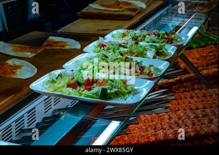 Insalata verde di verdure fresche per carne grigliata mista turca, ali di pollo, agnello, shashlik di manzo, kebab al ristorante Foto Stock