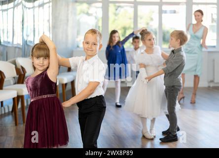 Danze classiche eseguite da bambini preadolescenti in abiti festivi Foto Stock