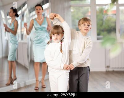 Ballerini Tween, ragazza e ragazzo che praticano il valzer in uno studio di danza Foto Stock