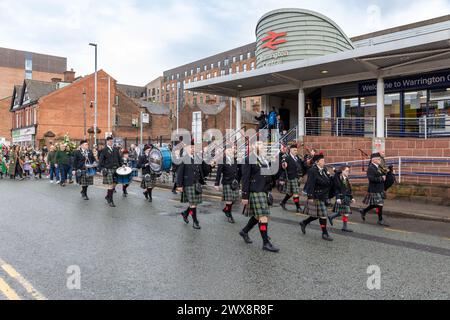 La Warrington Pipe Band passa dalla stazione ferroviaria centrale di Warrington, sfilata del giorno di San Patrizio 2024 Foto Stock