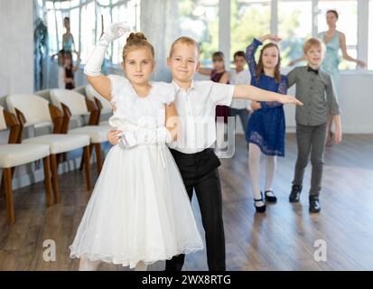 Danze classiche eseguite da bambini preadolescenti in abiti festivi Foto Stock
